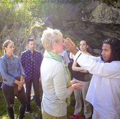 A group of tourists with a priest in the woods near Hotel Sumaq