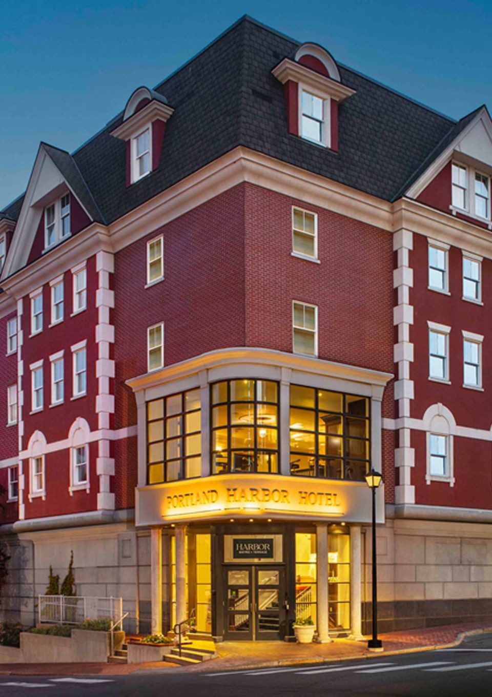 Exterior view of Portland Harbor Hotel with lit entrance