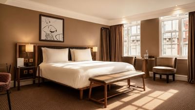 Elegant Collection Superior Room with a large bed and cozy seating area at The May Fair Hotel, London