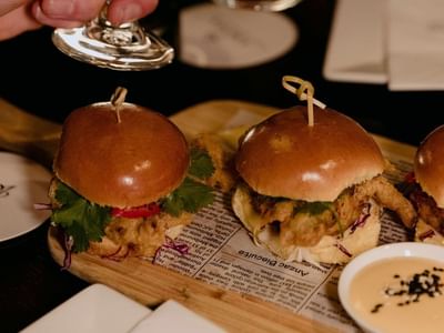 Close-up of Mini burgers served with a side of dip in Bar 649 at Amora Hotel Riverwalk Melbourne
