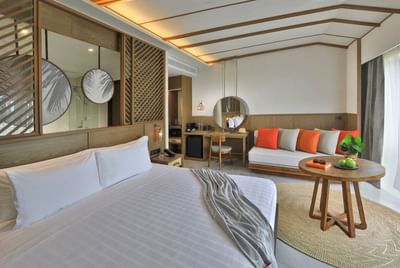 White sheeted bed and cozy sofa in a room at U Hotels
