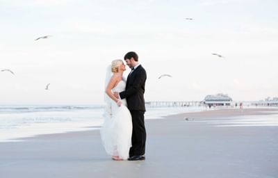 bride and groom embracing on the beach