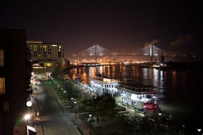 City skyline at night with a bridge near River Street Inn