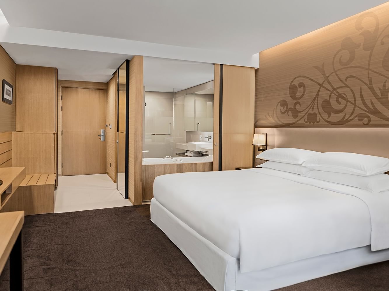Premier King at Paradox Bangkok Sukhumvit, with a bed by a glass bathroom wall, featuring comfy rooms in Bangkok, Thailand