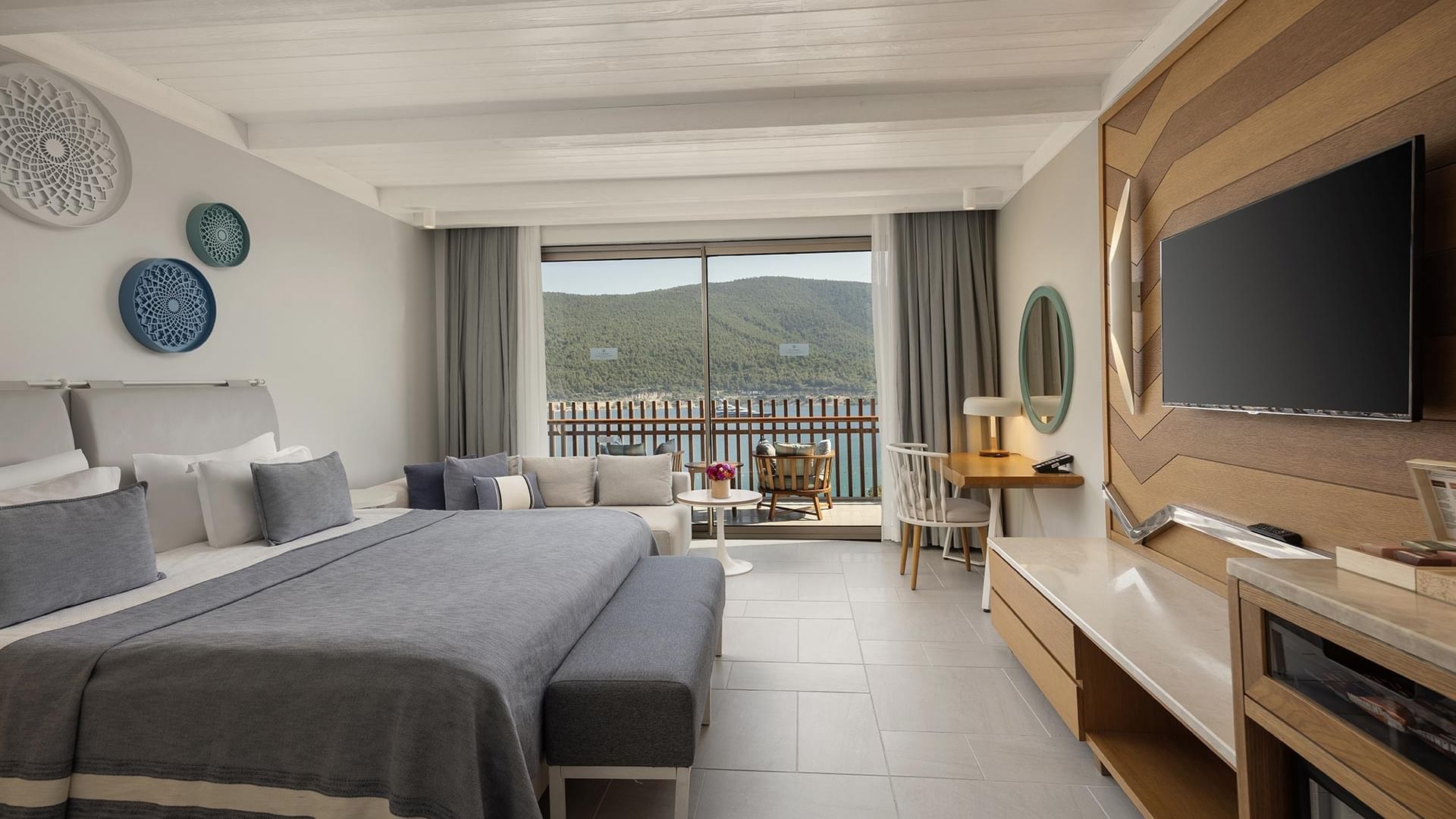 Стандартный номер с видом на море в отеле Titanic Luxury Collection Bodrum: просторная кровать, балкон, современный интерьер и большие окна с видом на море.