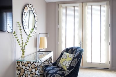 Dressing table with mirror, lamp & comfy chair in King Superior Den at Retro Suites Hotel