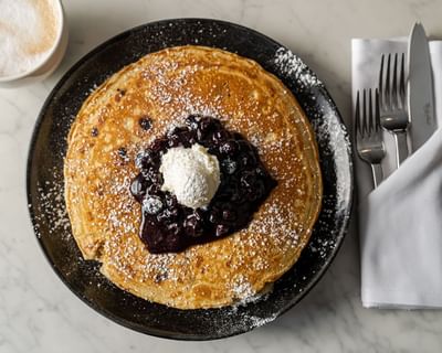 Pancakes topped with blueberries and powdered sugar in Harbor Bistro at Portland Harbor Hotel