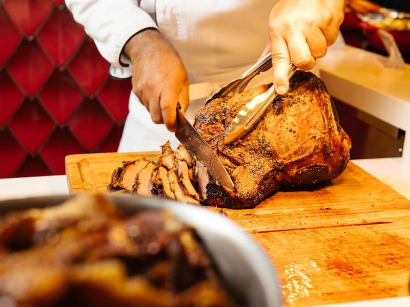 A Chef Cutting meat in Atrium restaurant at Crown Hotel Perth