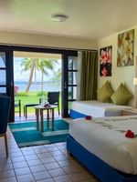 Two beds and balcony with ocean view in a room at The Naviti Resort in Korolevu.
