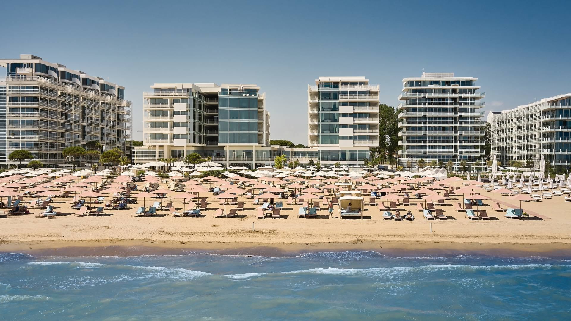 Exterior view of Falkensteiner Hotel & Spa Jesolo with umbrellas & sun loungers