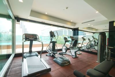 Interior view of the gym with exercise equipment at Amora Neoluxe Hotel Bangkok