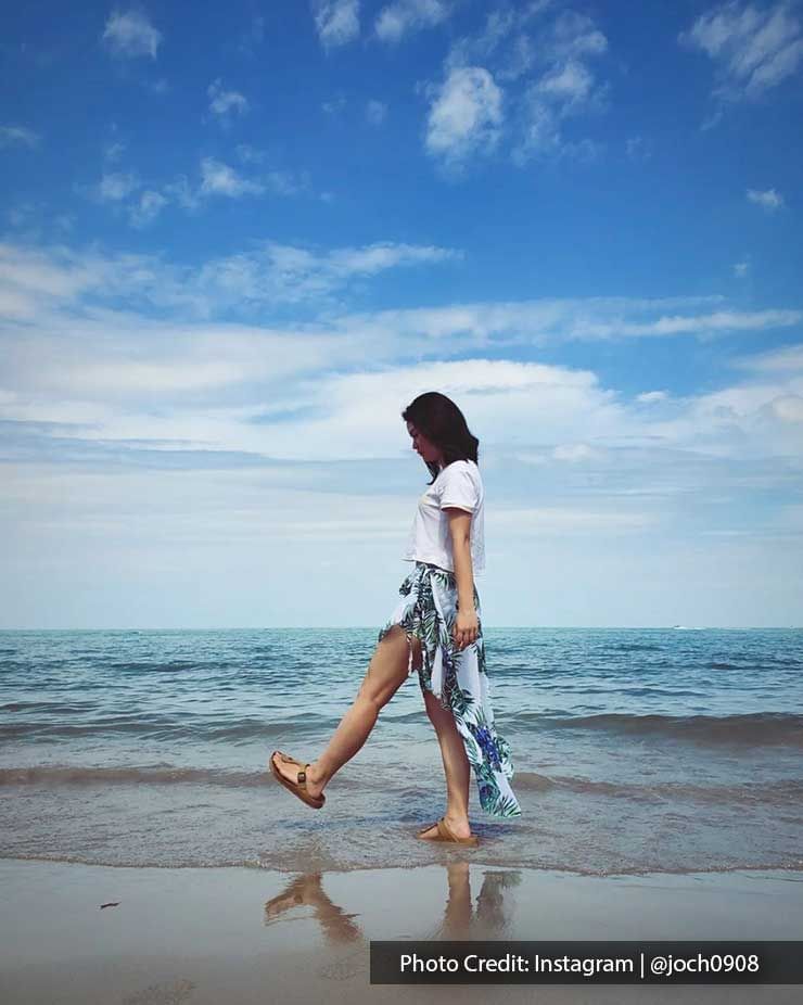 a girl walking along the beach shore