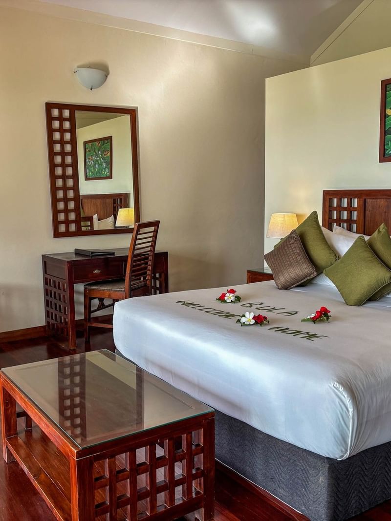 Studio Villa room at The Naviti Resort in Korolevu with bed, desk, chair, and wooden furniture.