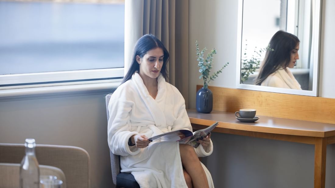 A lady reading her book and enjoying the view in the Superior Suite