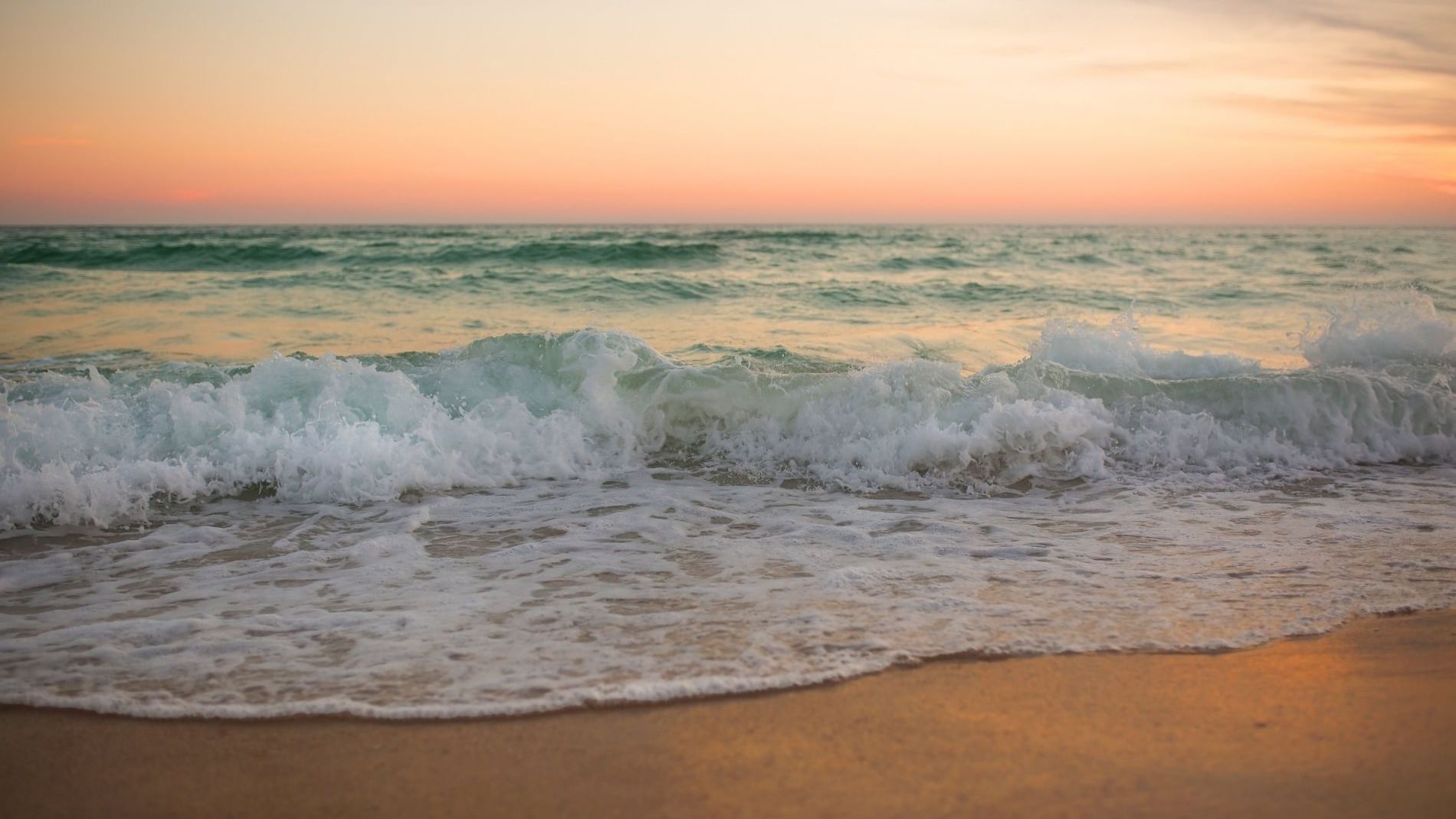 View of waves on the beach at sunset near WaterColor Inn