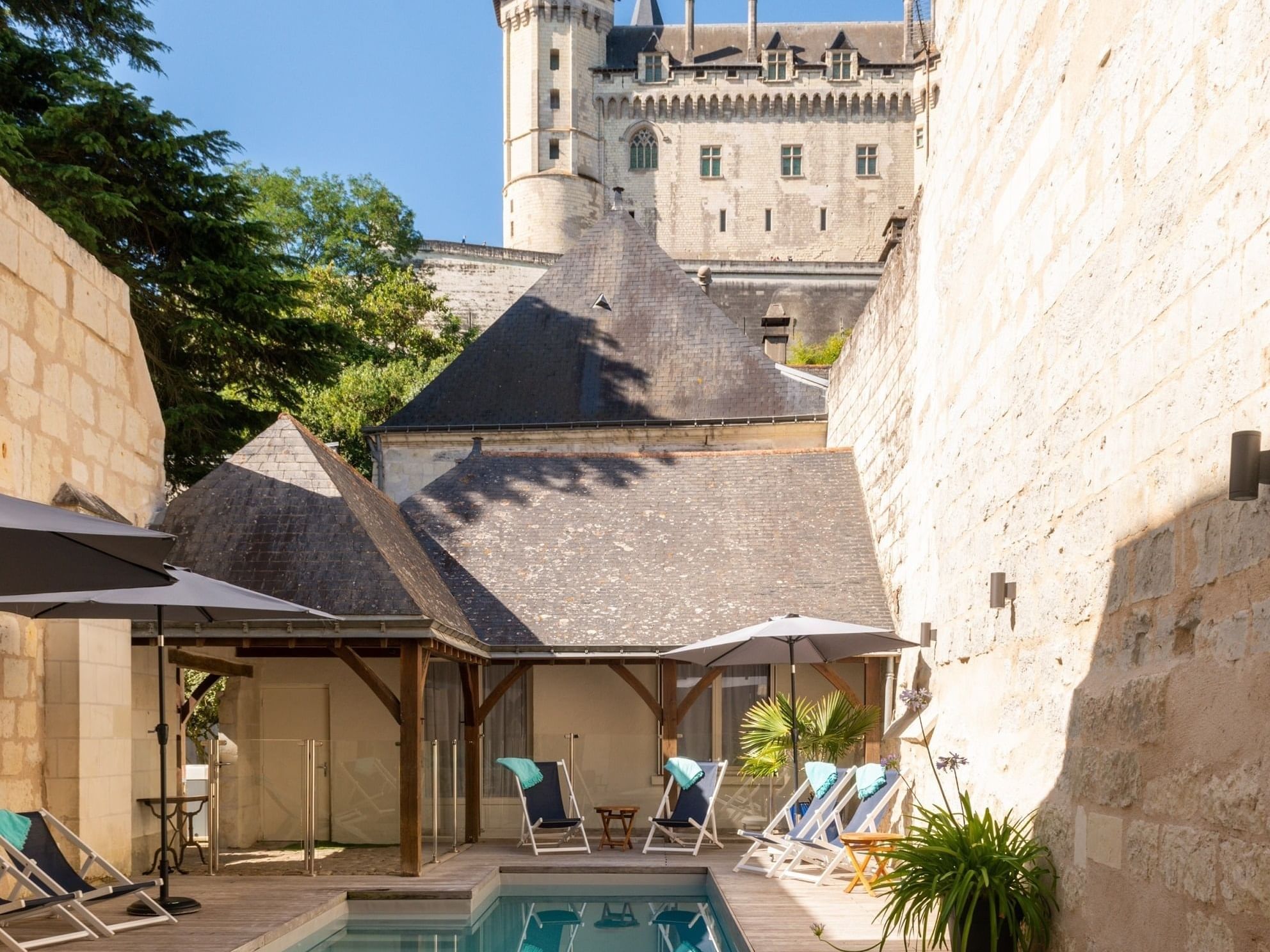 A plunge pool with a pool chairs by it in Originals Hotels