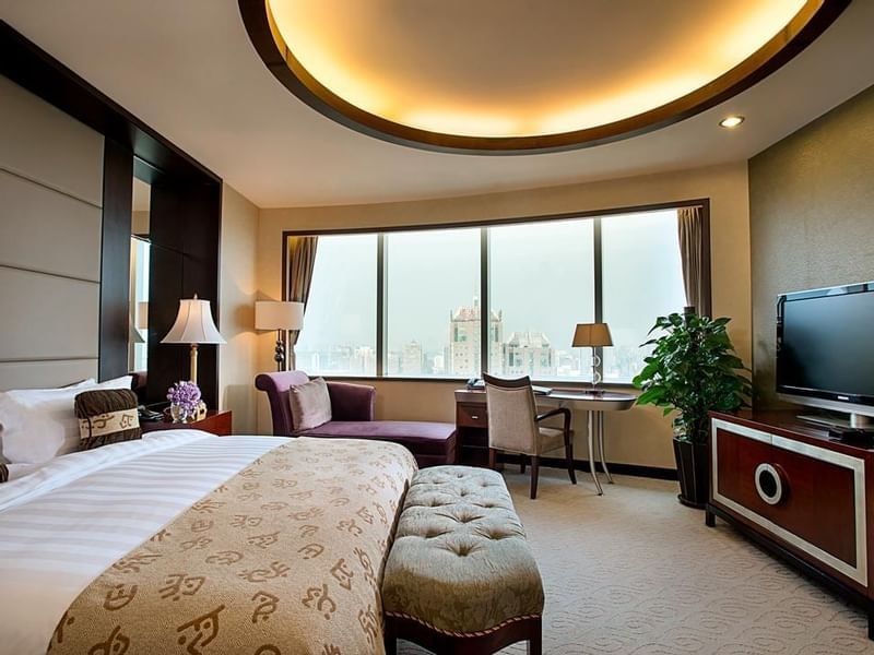 TV facing bed with couch by the window in Yu Ting Imperial Suite at Celebrity International Grand Hotel