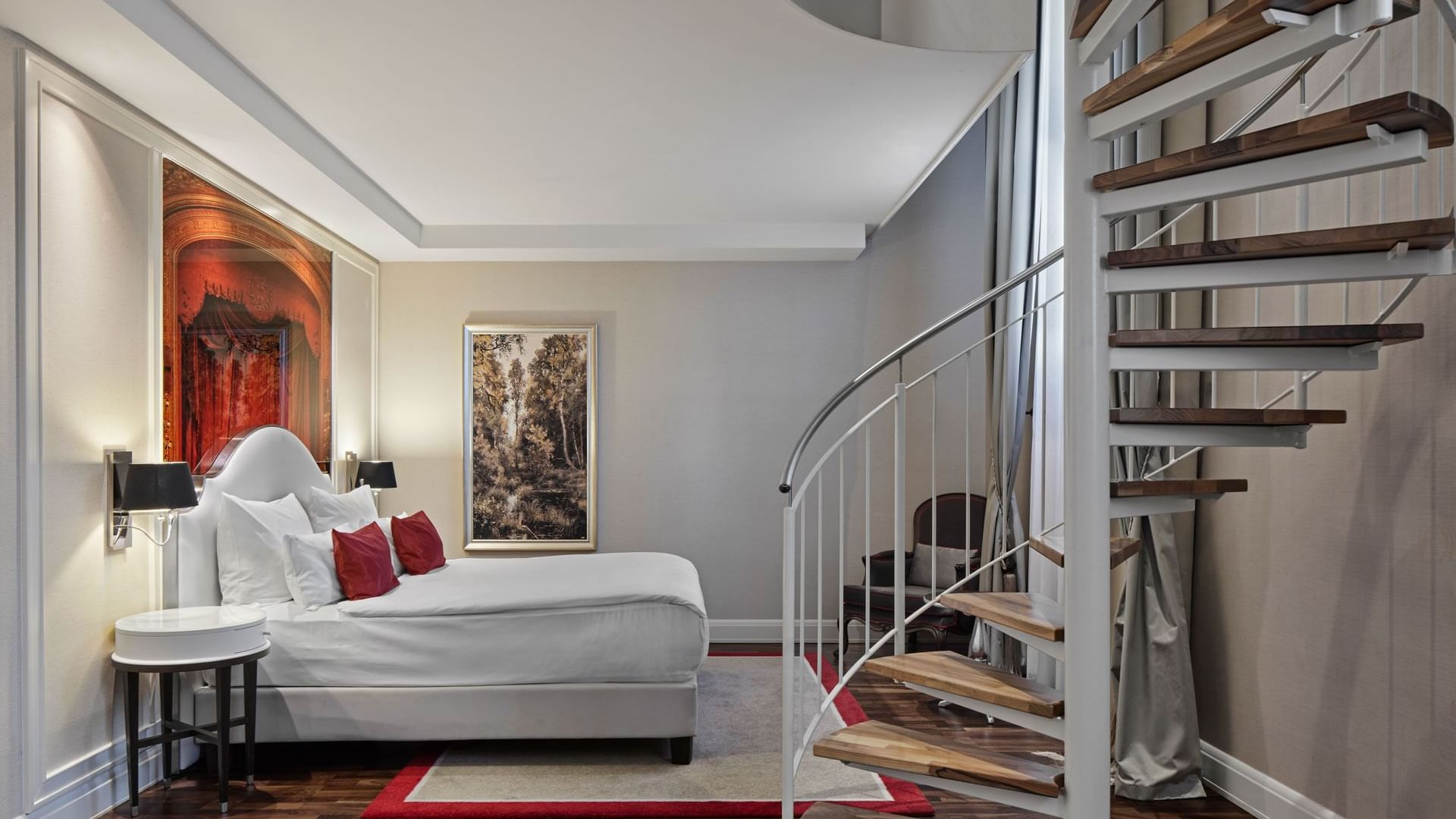 Bedroom with a spiral staircase and modern furniture in Gendarmenmarkt Duplex Suite at Titanic Gendarmenmarkt Berlin