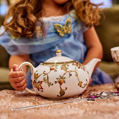 A woman holding a teapot at afternoon tea in The Townsend Hotel