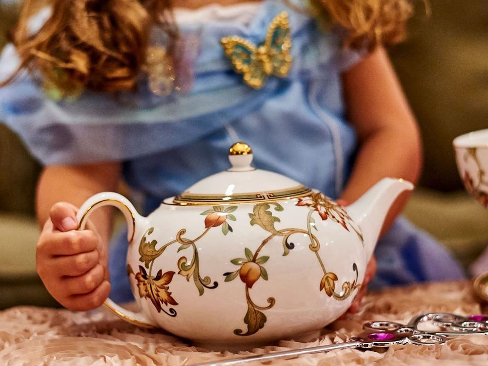 A woman holding a teapot at afternoon tea in The Townsend Hotel