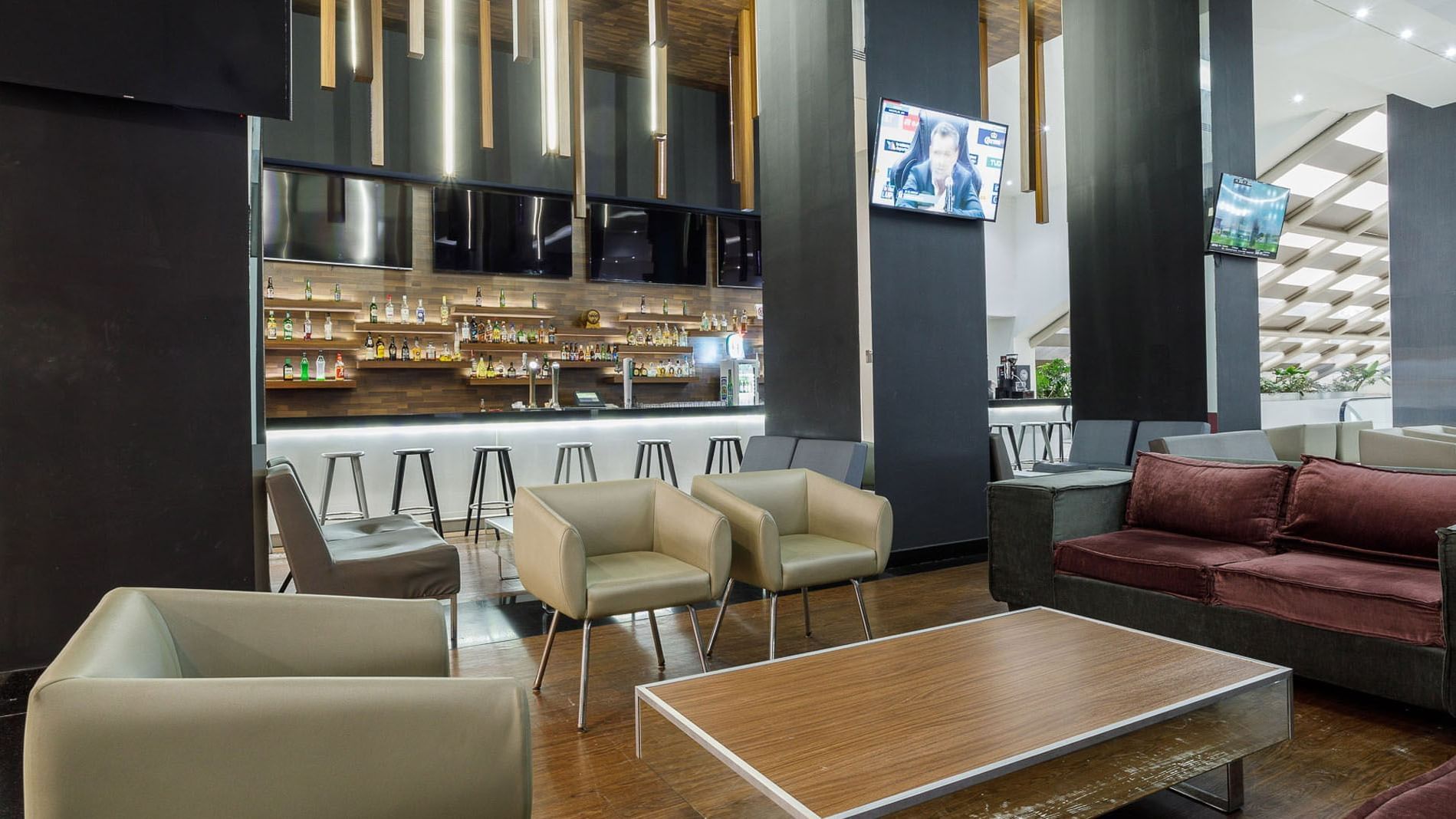Stock Bar featuring a bar counter and shelves with bottles mounted on the wooden wall at Real Inn Tijuana
