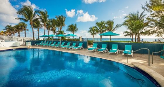 Outdoor pool with sun beds by ocean at Marenas Resort Miami
