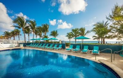 Outdoor pool with sun beds by ocean at Marenas Resort Miami