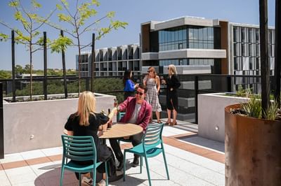 People lounging in the Rooftop lounge at Nesuto Curtin Perth