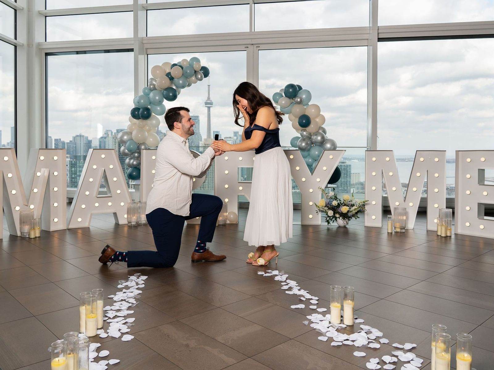 Couple getting engaged overlooking the skyline