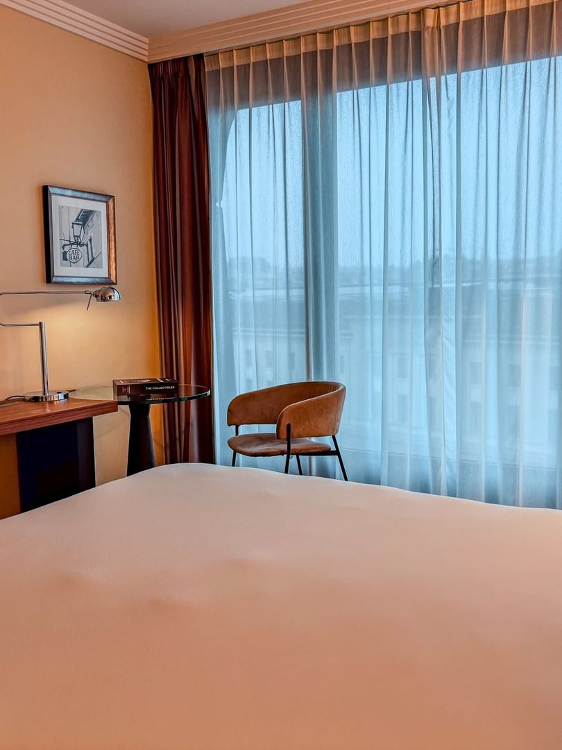 Intérieur d'une chambre Supérieure au Warwick Geneva à Genève, avec lit, rideaux et mobilier.
