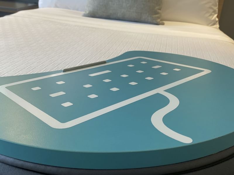 Primer plano sobre la almohada de la bandeja del portátil sobre una cama en One Hotels