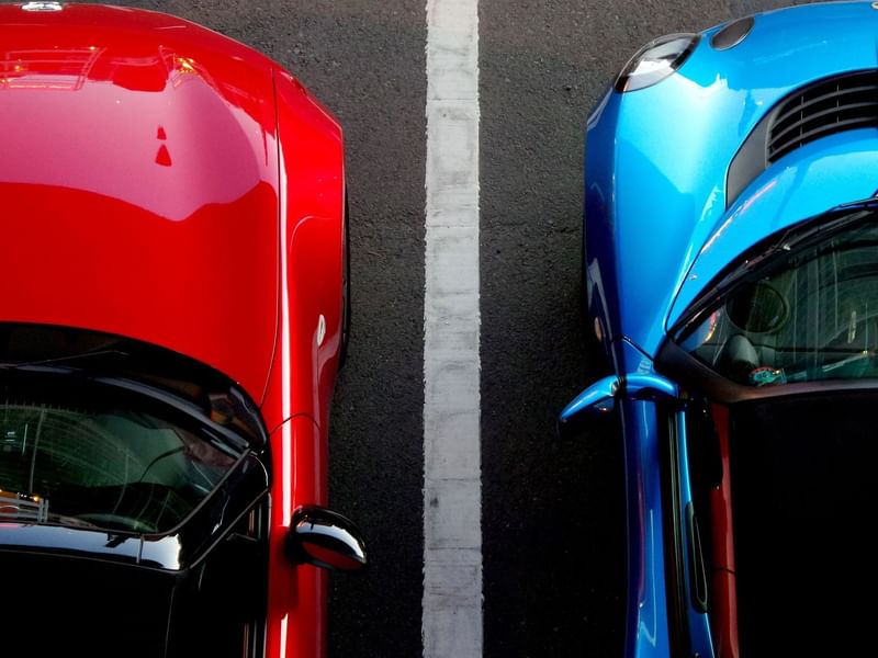 Birds eye view of a red car next to a blue car