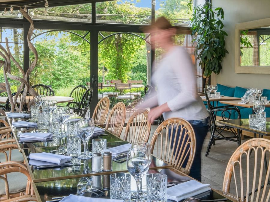 A maid puts up dining chairs at Domaine de bellevue