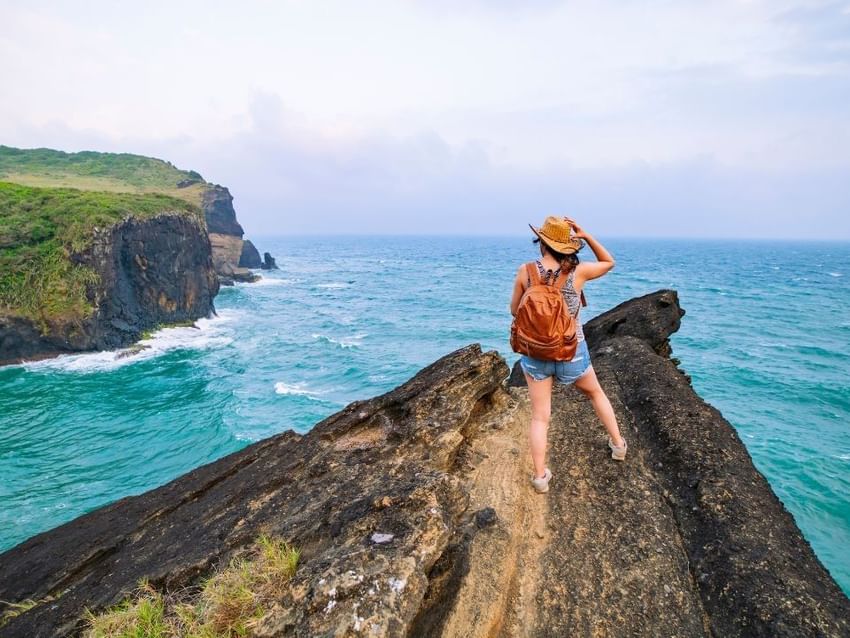 Guest with a backpack looks at the ocean cliffs near Camino Real Veracruz