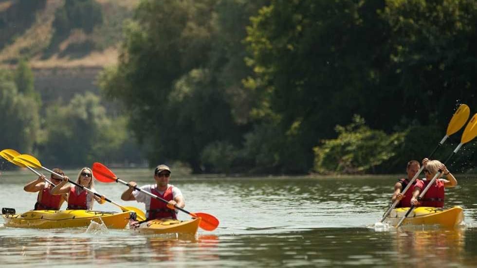 Group of people wearing lifejackets kayaking on a river near Falkensteiner Hotel Belgrade