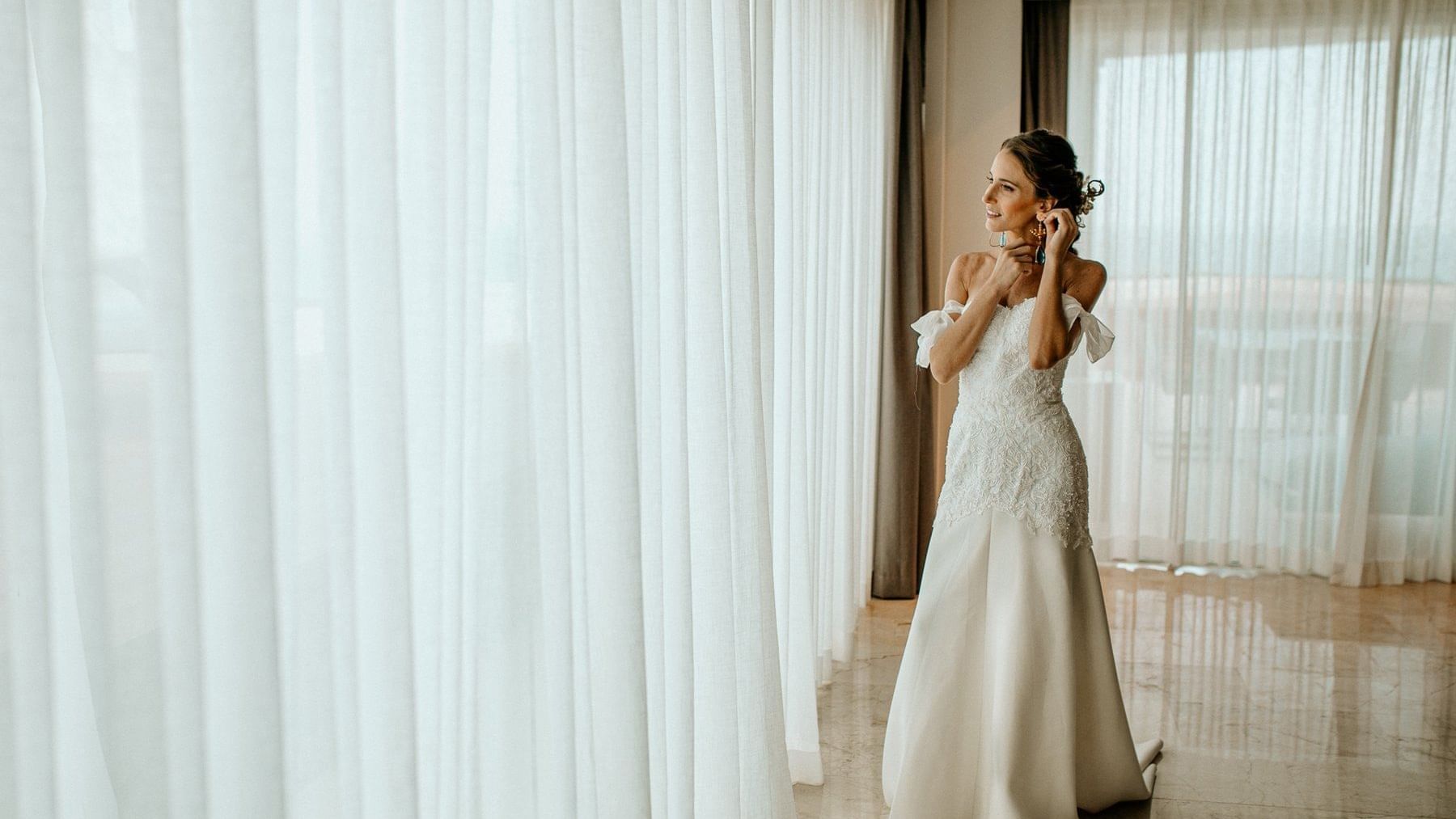 Bride getting ready beside a window in a room at FA Reforma