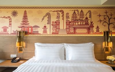 Comfy bed with wall art in Superior Room at Eastin Ashta Resort Canggu