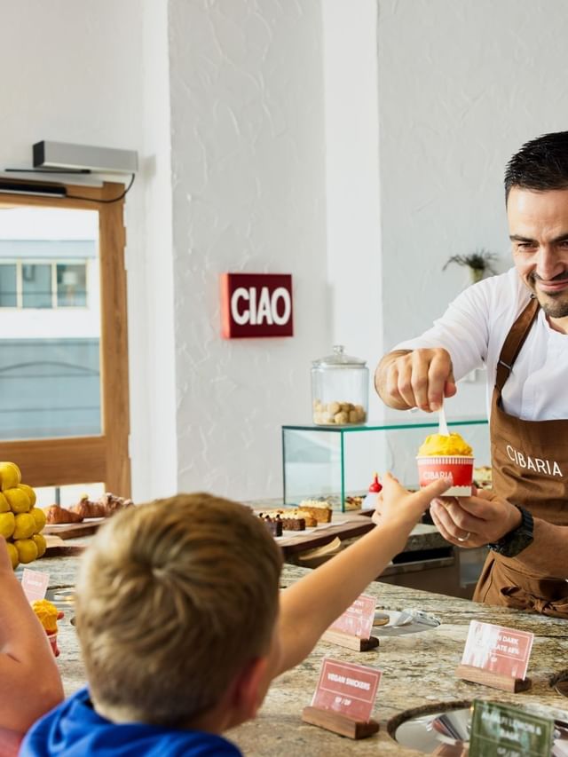 Cibaria Caffetteria & Gelateria at Elysium Manly, featuring a server by kids surrounding a curved stone counter