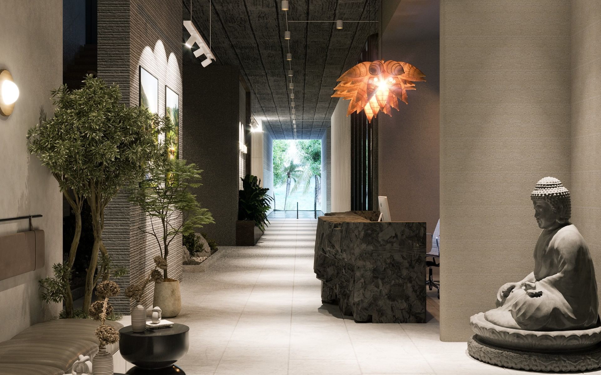 The LifeCo Wellness Center lobby with a dark stone counter, a unique light fixture, and a Buddha statue at A’ila Resorts
