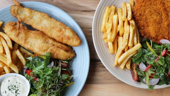 Fried fish served with french fries and spinach at Nesuto Parramatta