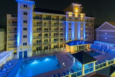 Exterior view of Park Place Hotel Ocean City MD with glowing balconies and pool