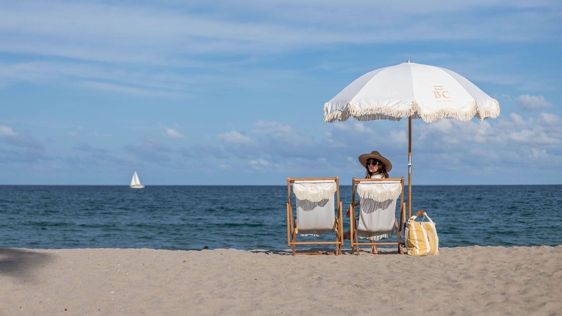 Women on a lounge on the private beach at Brazilian Court