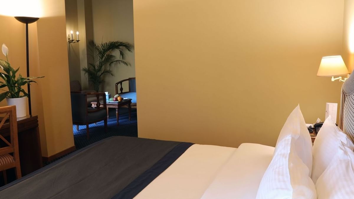 Bed beside a doorway leading to the living area in Junior Suite at Warwick Palm Beach Hotel