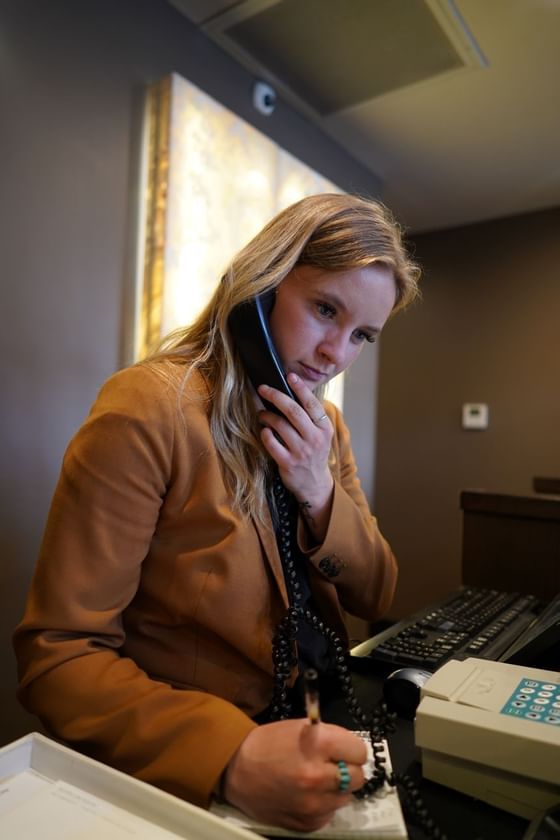 Receptionist answering a phone call by the desk, Hotel Jackson