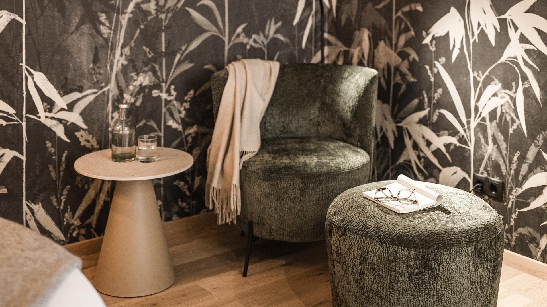 Gemütliche Loungeecke mit Lesematerial und Getränken in der Premium Suite Bergliebe am Falkensteiner Hotel Antholz.