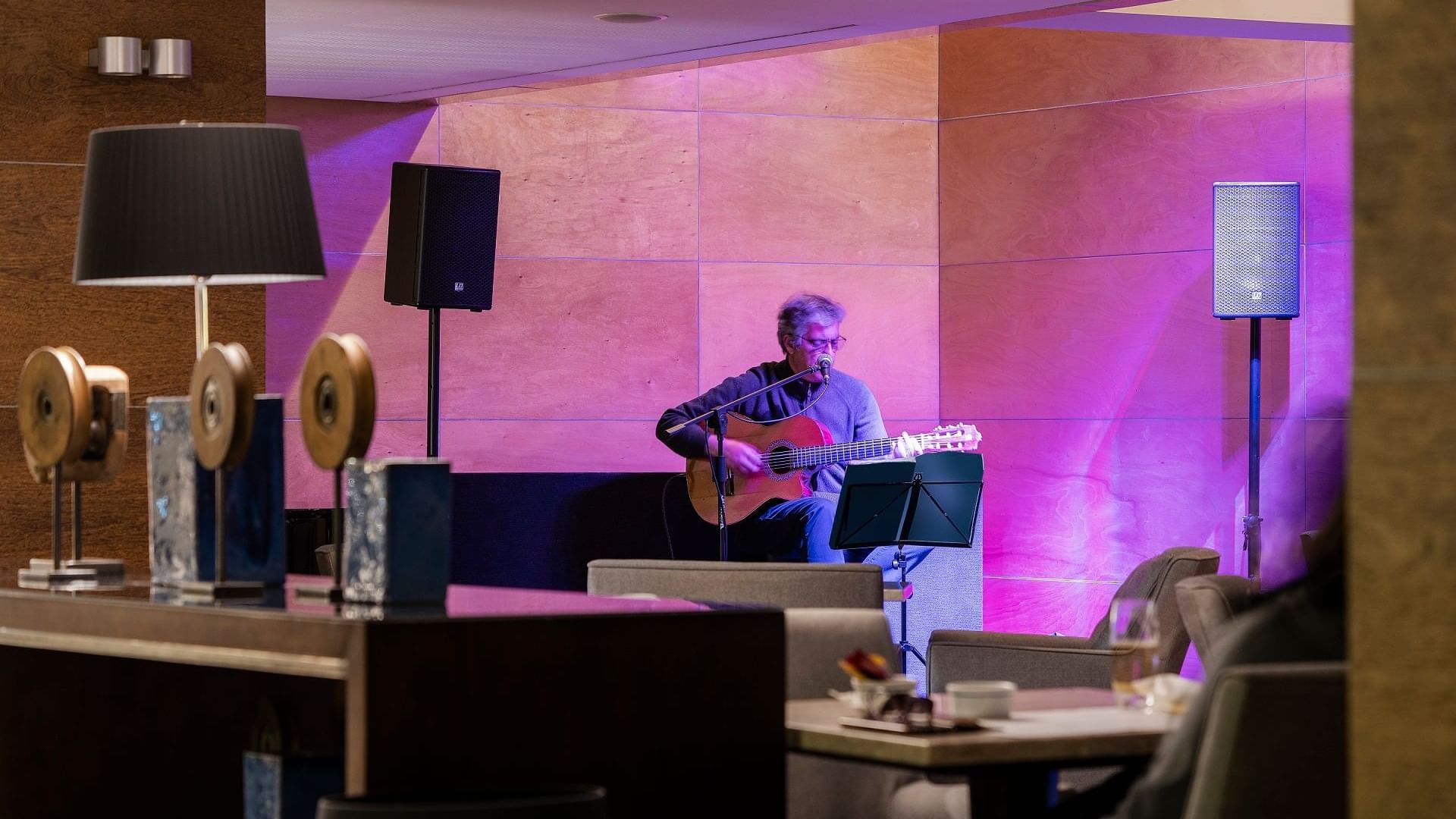 Performer playing a guitar in Palhabote Bar dining area at Hotel Marina Atlântico