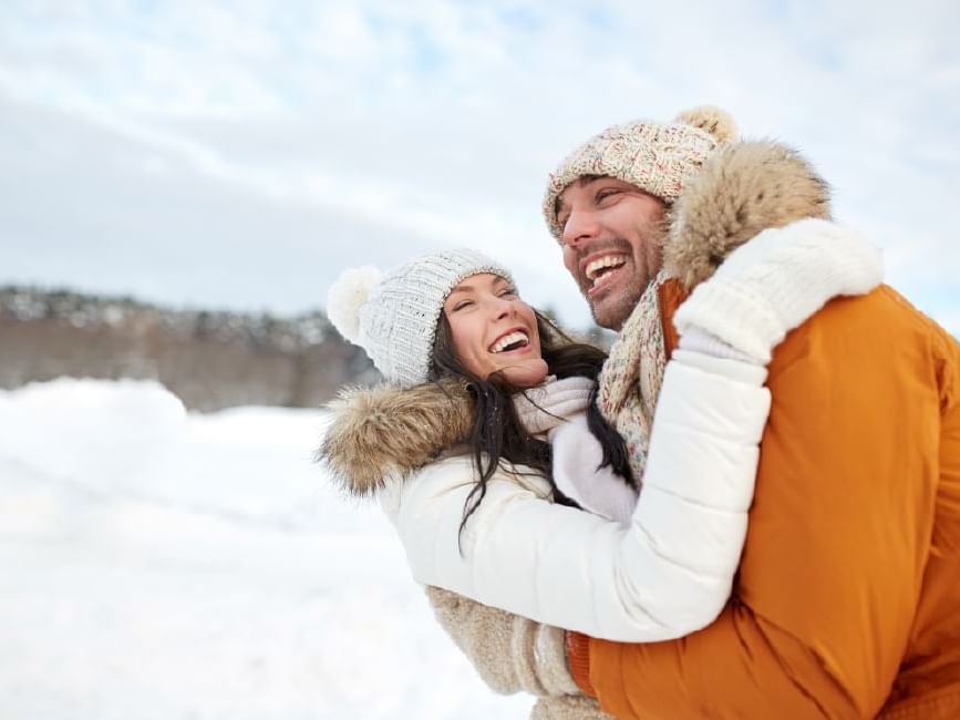 happy couple playing in the snow because they scored a huge discount by being rsvp rewards loyalty members