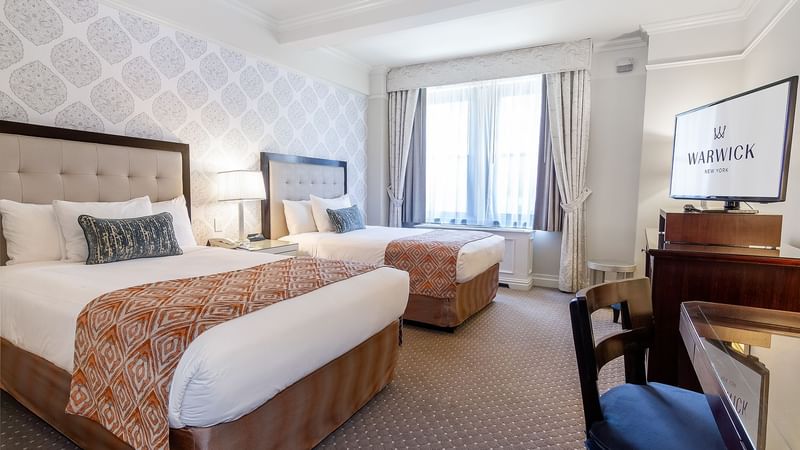 TV & work desk by the beds in Premier City View at Warwick New York