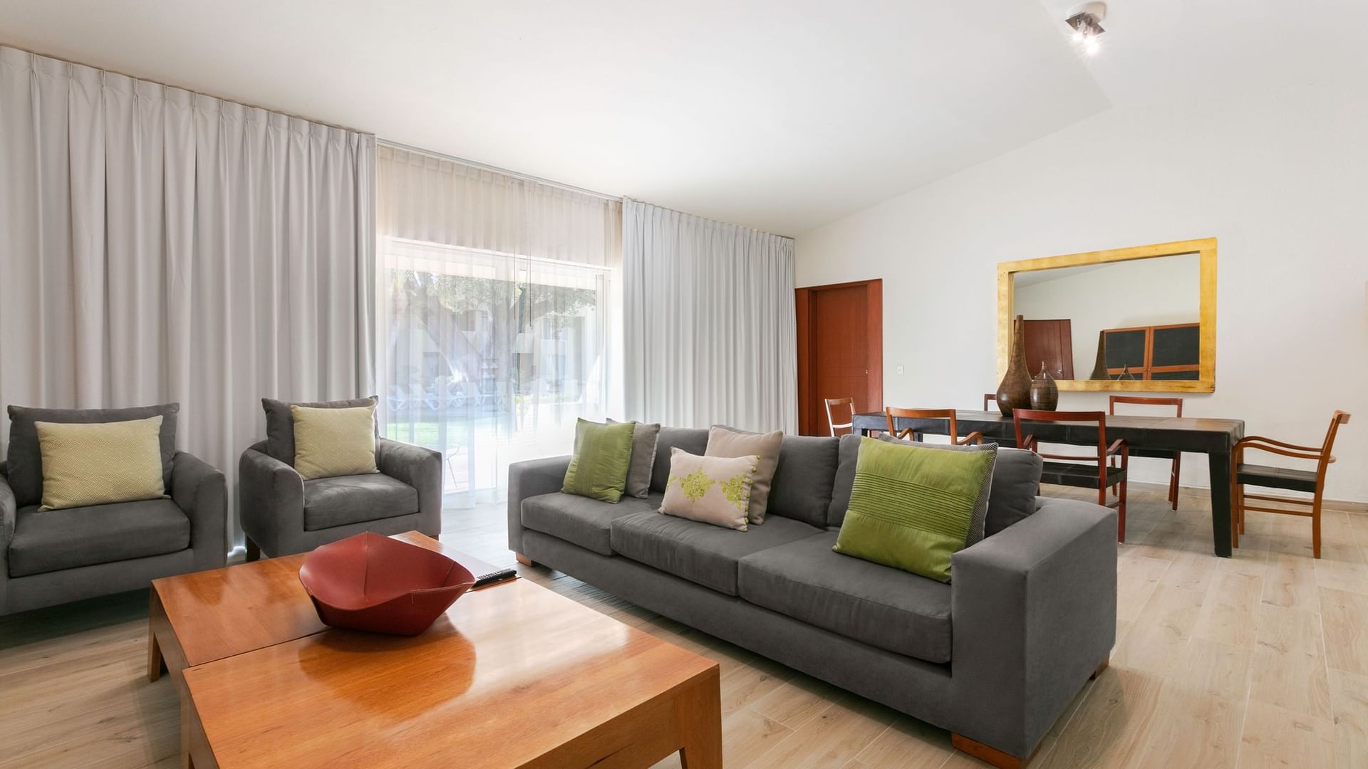 Living area with a gray sofa and armchairs in the King Presidential Suite at Camino Real Guadalajara in Zapopan