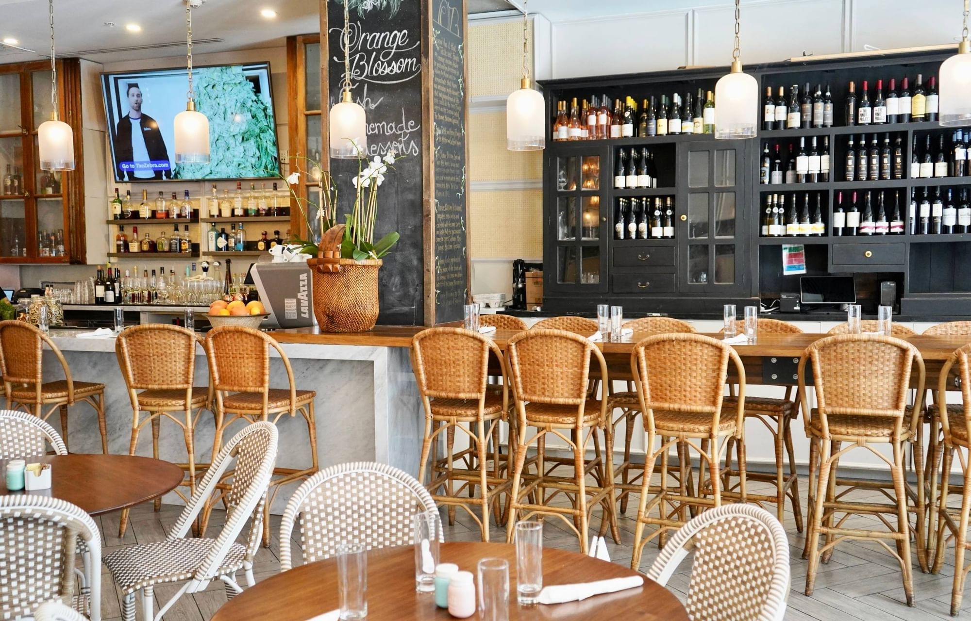 A dining area with tables and chairs, a bar, and wine storage.